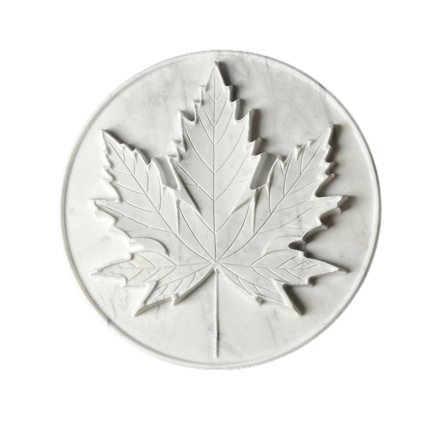 White marble tray with an intricately carved maple leaf design.