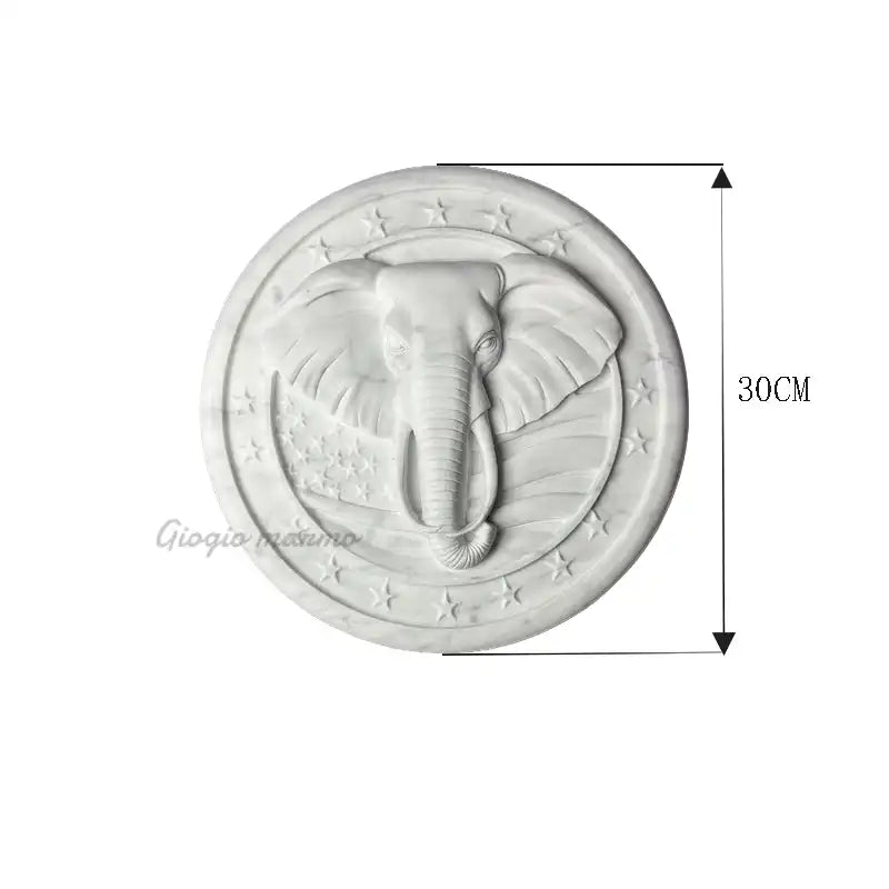 White marble relief sculpture featuring an intricately carved elephant head with star accents.