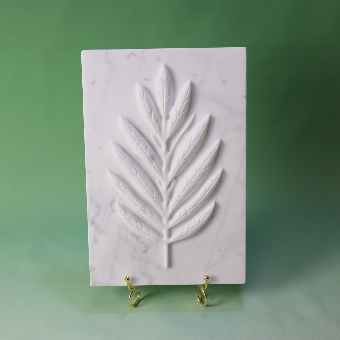 White marble plate with intricately carved olive leaves design, perfect for decorative use.